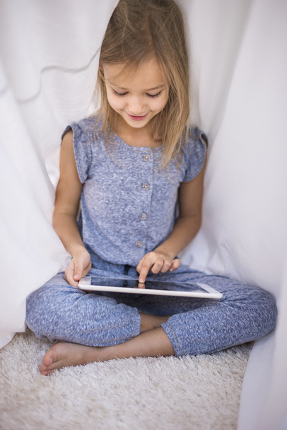 Girl Browsing digital tablet at the duvet - Foto, imagen