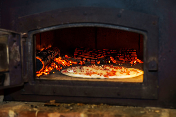 Pizza cooking in natural vintage stove - Foto, imagen