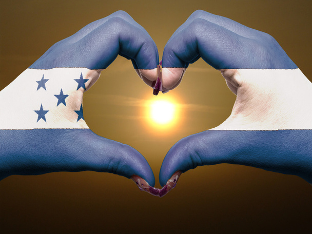 Corazón y gesto de amor con las manos coloreadas en bandera de honduras durante
 - Foto, Imagen