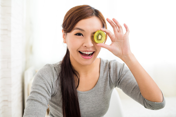 woman showing slice of kiwi fruit - Φωτογραφία, εικόνα