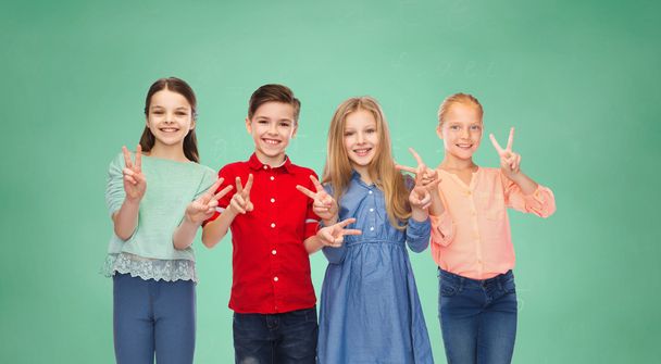 happy boy and girls showing peace hand sign - Foto, imagen