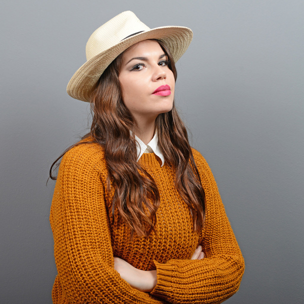 Portrait of urban looking woman in sweater and hat against gray  - Fotoğraf, Görsel