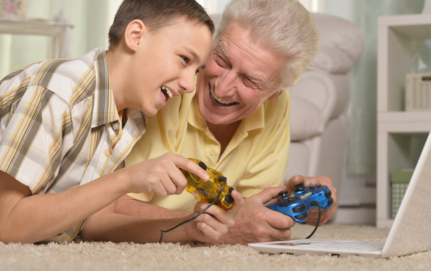 jongen en grootvader spelen van computerspel - Foto, afbeelding