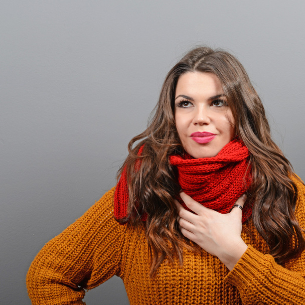 Portrait of young woman in winter clothes against gray backgroun - Fotó, kép