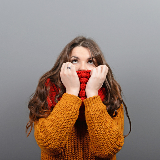 Porträt einer jungen Frau in Winterkleidung, die gegen Gra aufblickt - Foto, Bild