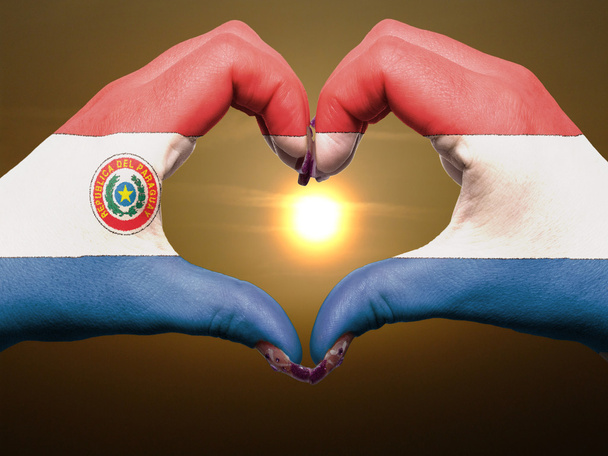 Corazón y gesto de amor con las manos coloreadas en bandera de paraguay durante
 - Foto, Imagen