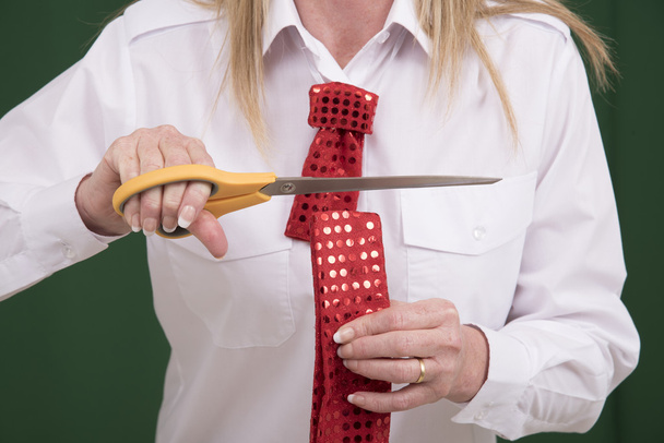 Большая пара ножниц разрезает галстук пополам
 - Фото, изображение