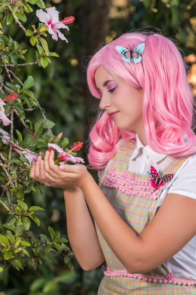 young girl with a pink wig posing as in the park - Photo, Image