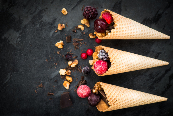 Замороженные ягоды, грецкие орехи, шоколад и вафельные конусы
 - Фото, изображение