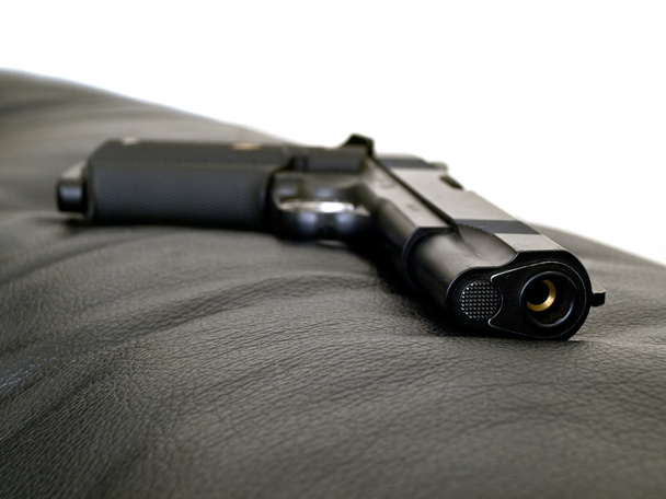 Pistolet en acier noir sur cuir
 - Photo, image
