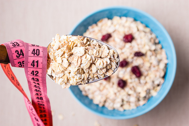 Oatmeal in bowl and measuring tape - Photo, Image