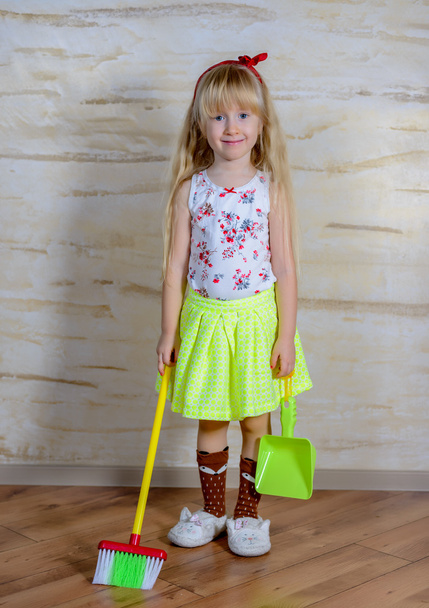 Чарівна маленька дівчинка з іграшковою мітлою і сковородою
 - Фото, зображення