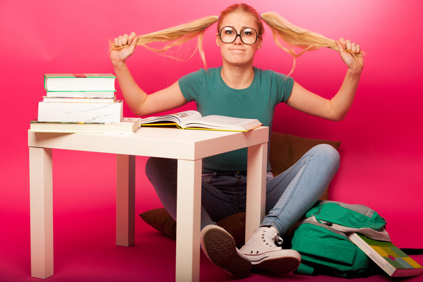 Frustrated schoolgirl with big eyeglasses pulling hair tails not - Φωτογραφία, εικόνα