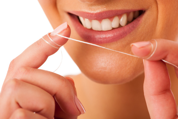 Kobieta, czyszczenie zębów z nici dentystyczne dla doskonałą higienę i h - Zdjęcie, obraz
