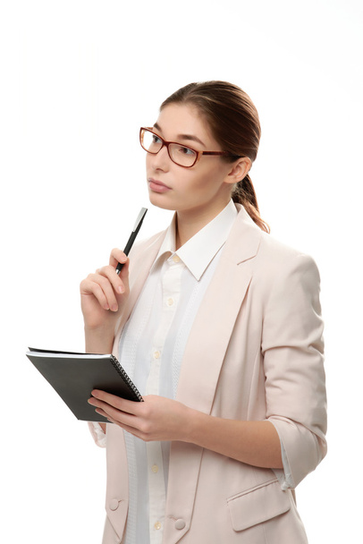 Young stylish woman standing holding a notepad and a pen. - Foto, imagen