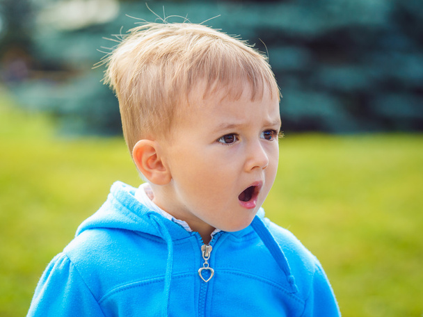 Retrato de niño caucásico primer plano con capucha azul
 - Foto, imagen