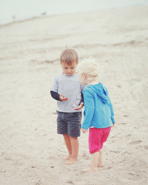 děti na pláži hraje sbíráme mušle - Fotografie, Obrázek