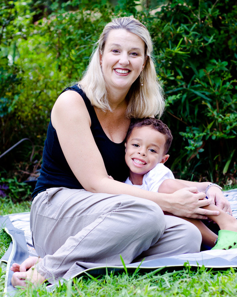 Portrait of happy mother and mixed race son outdoors at park - Foto, imagen