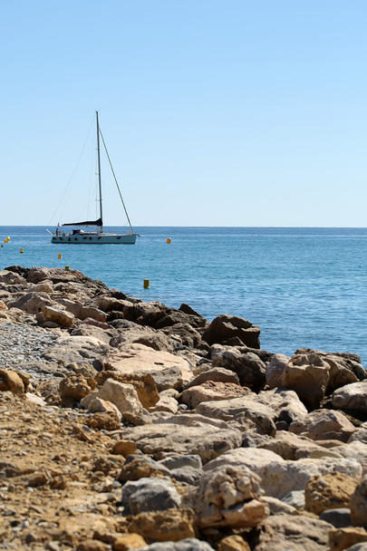 Stone coast and yacht offshore - Fotó, kép