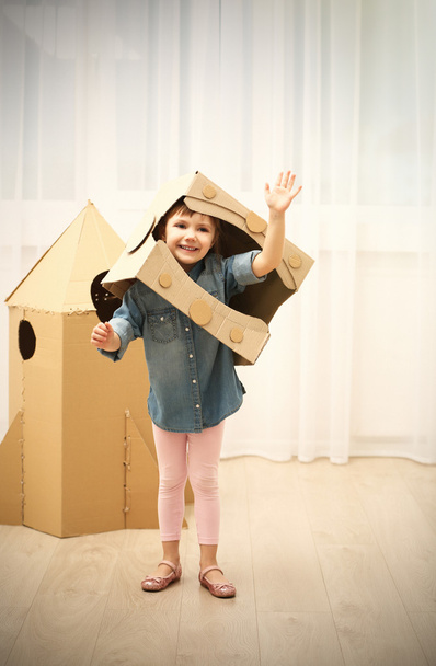 Girl playing with cardboard space rocket - Фото, изображение