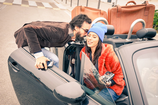 Magabiztos csípő srác szórakozik a divat barátnője - boldog pár készen áll elhagyni az autó utazás - Modern szeretet kapcsolat fogalmát az emberek utazás együtt - fő hangsúly a barátja arca - Fotó, kép