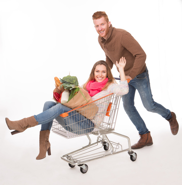 Happy couple with shopping cart - Foto, imagen