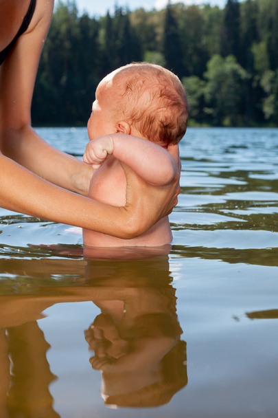 Mutter badet Säugling im Freien - Foto, Bild