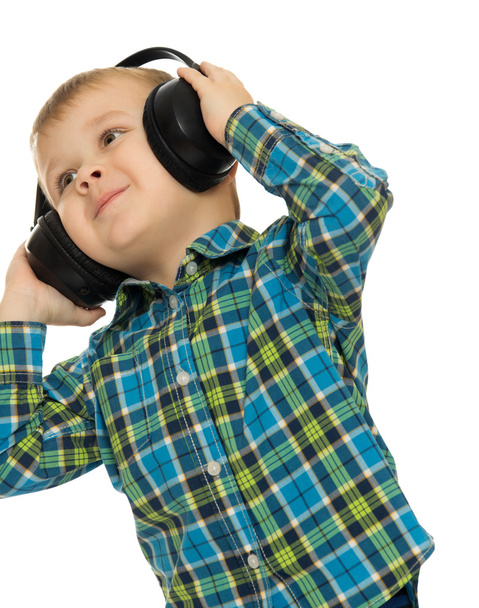 The boy listens through headphones music - Fotó, kép