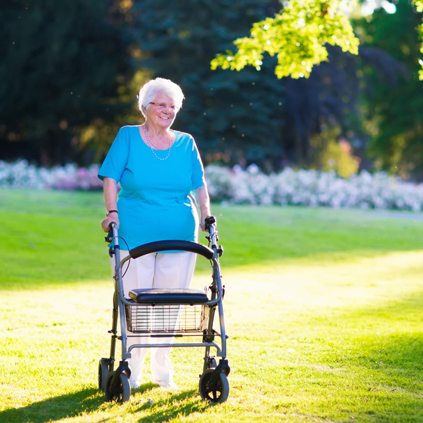 Άτομα με ειδικές ανάγκες ηλικιωμένης με έναν περιπατητή σε ένα πάρκο - Φωτογραφία, εικόνα