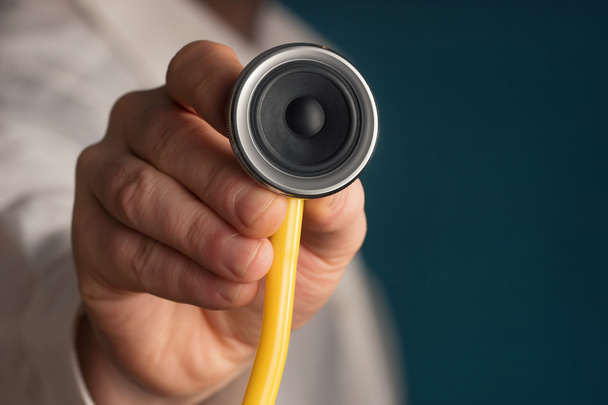 Arzt hält ein Stethoskop mit einem Lautsprecher in der Hand - Foto, Bild