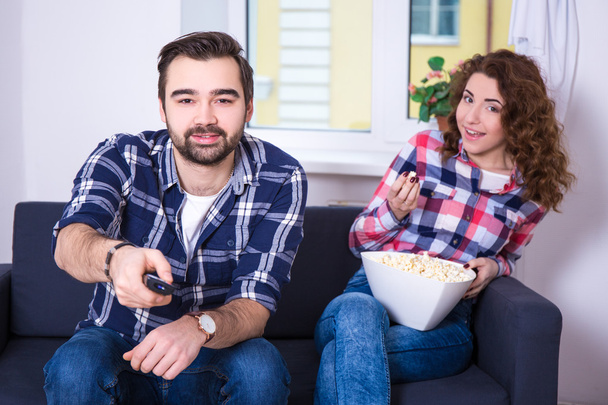 pareja joven con palomitas de maíz viendo televisión o una película - Foto, imagen