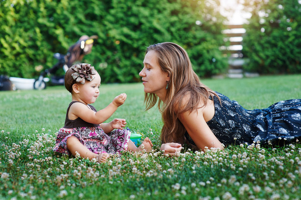 jeune mère et sa petite fille jouant sur l'herbe
 - Photo, image