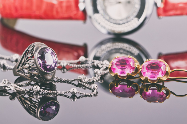Pendientes y anillos de oro con rubíes rojos y reloj
 - Foto, imagen