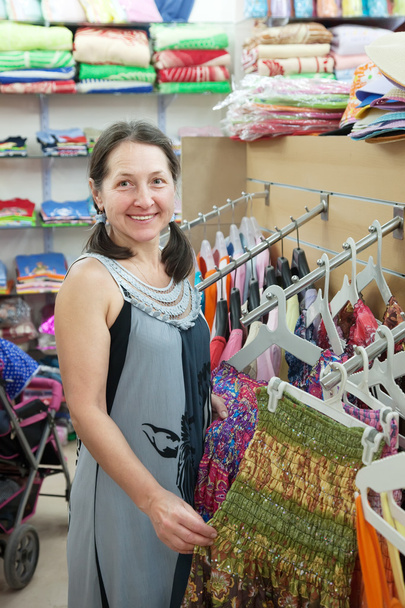 Mature woman chooses dress at shop - Photo, Image