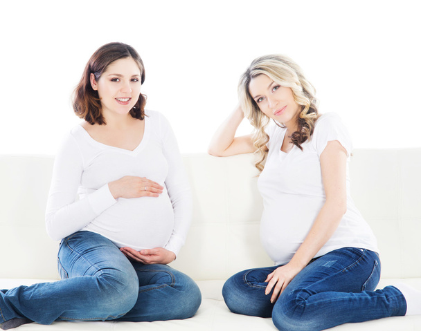 Duas mulheres grávidas em um sofá
 - Foto, Imagem