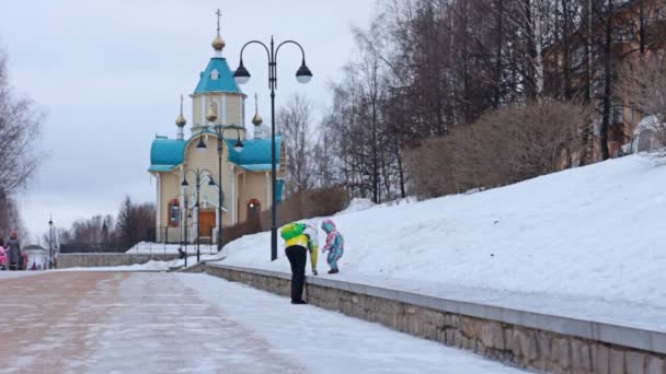Una madre y un niño están caminando cerca de una iglesia rusa en invierno
 - Metraje, vídeo