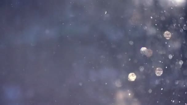 Un fondo azul de nieve cayendo en los rayos del sol
 - Metraje, vídeo