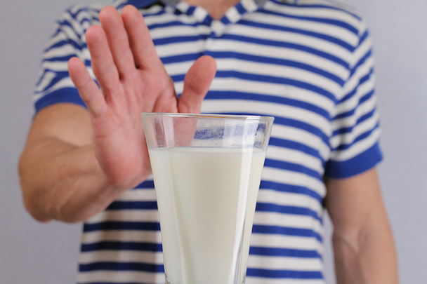 Lactose intolerance. Dairy Intolerant man refuses to drink milk - 写真・画像