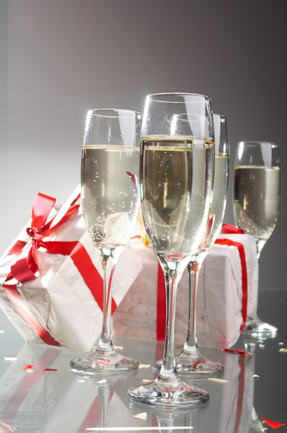sklenice šampaňského, dárky s červený pásek a luky - Fotografie, Obrázek