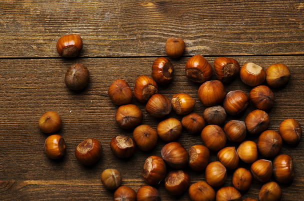 pile of hazelnuts in shell on wooden table  - Valokuva, kuva