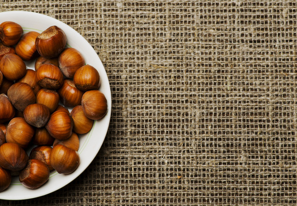 pile of hazelnuts in shell on wooden table  - Fotó, kép