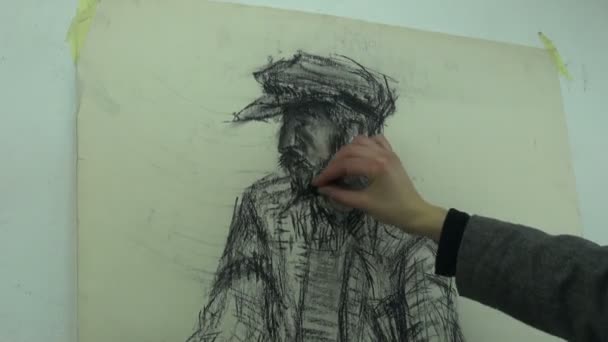 Drawing a fast sketch of a man's head with a cap with a charcoal stick - Πλάνα, βίντεο