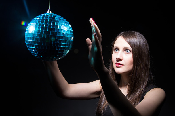 Brunette woman touching disco ball - Photo, Image