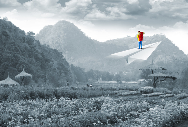 Mochilero miniatura en avión de papel en la montaña
 - Foto, Imagen
