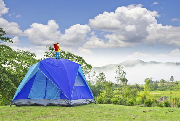 Миниатюрный турист на синей палатке в горах
 - Фото, изображение