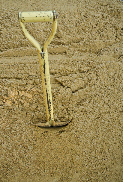 Pala amarilla sobre arena
 - Foto, imagen