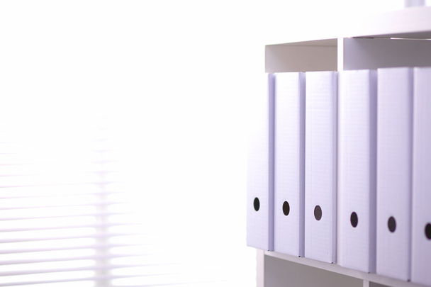 File folders, standing on  shelves in the background - Photo, Image