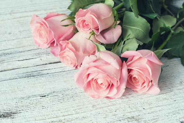 Beautiful pink roses on vintage wooden background. Retro style - 写真・画像
