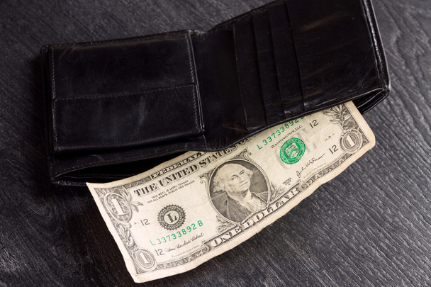 Black leather wallet with one dollar. Concept: poverty - Photo, Image