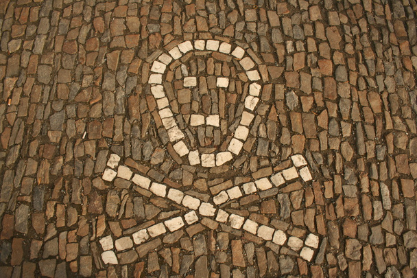 Símbolo de huesos cruzados y cráneo creado a partir de guijarros blancos en el suelo. Tomado en Sedlec, Kutna Hora ossuary, República Checa
 - Foto, Imagen